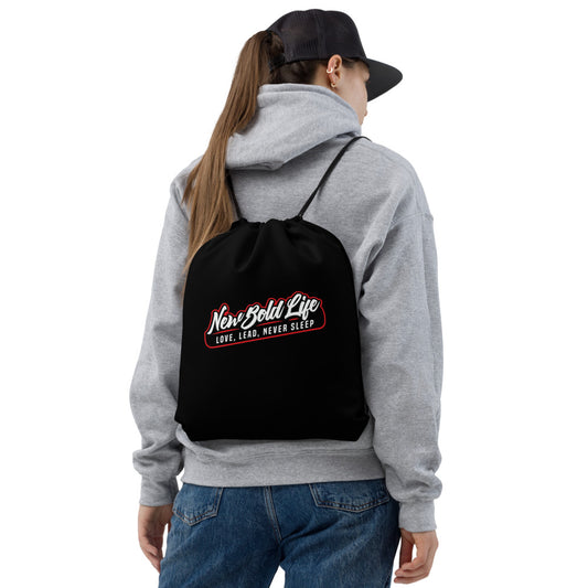 Model wearing a black New Bold Life Drawstring Bag - Accessories, with large Newboldlife logo on the  back.