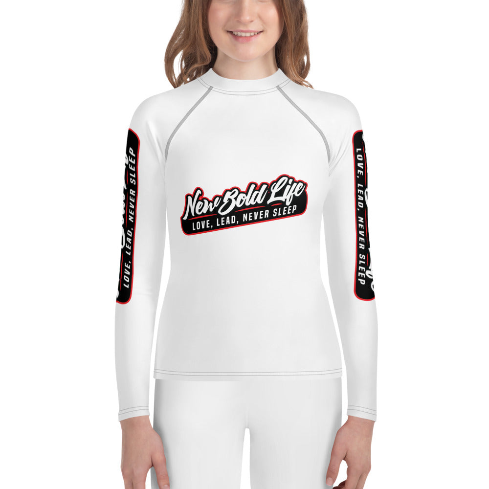 Young model wearing New Bold Life Youth Rash Guard - Kid's Clothing. Product has long sleeves, both with logos, and large logo on center of chest.