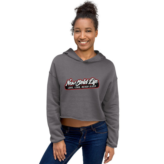 Model wearing a charcoal-grey New Bold Life - Ladies Crop Hoodie - Women's Apparel. Large Newboldlife logo on front.